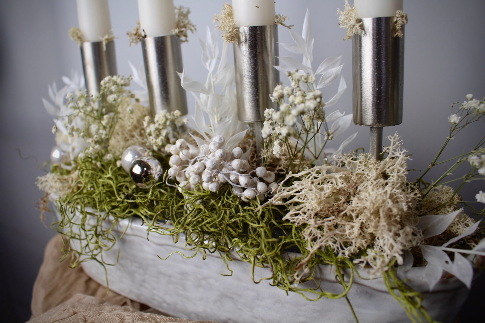 Close-up Adventsgesteck Weiß-Silber mit Trockenblumen in weißer Keramikschale