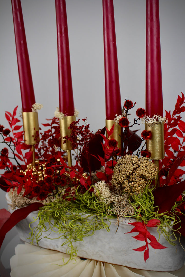 Detailaufnahme Adventsgesteck in Rot & Gold mit Stabkerzen in weißer Keramikschale
