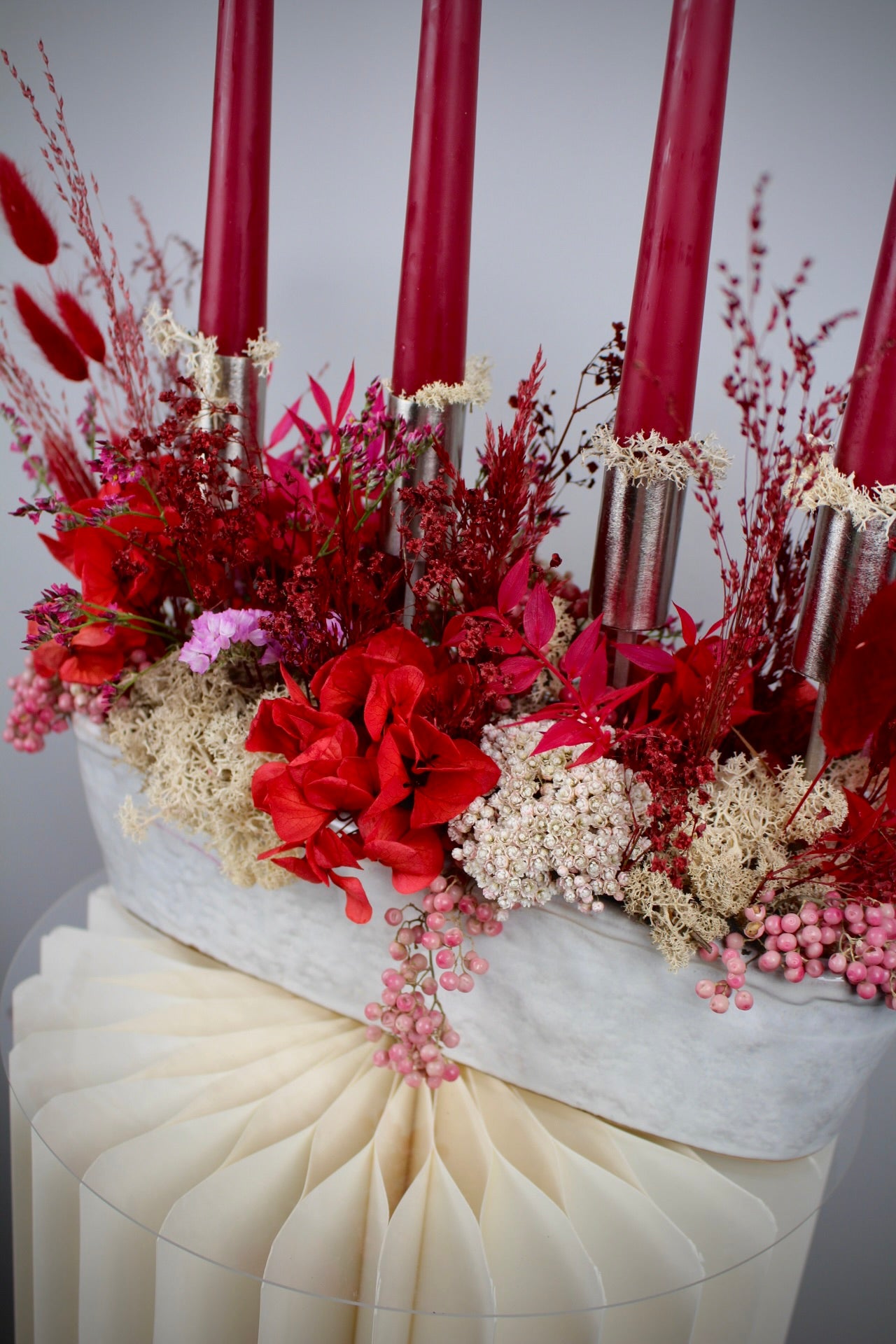 Detailaufnahme Adventsgesteck in Rot & Silber mit Stabkerzen in weißer Keramikschale