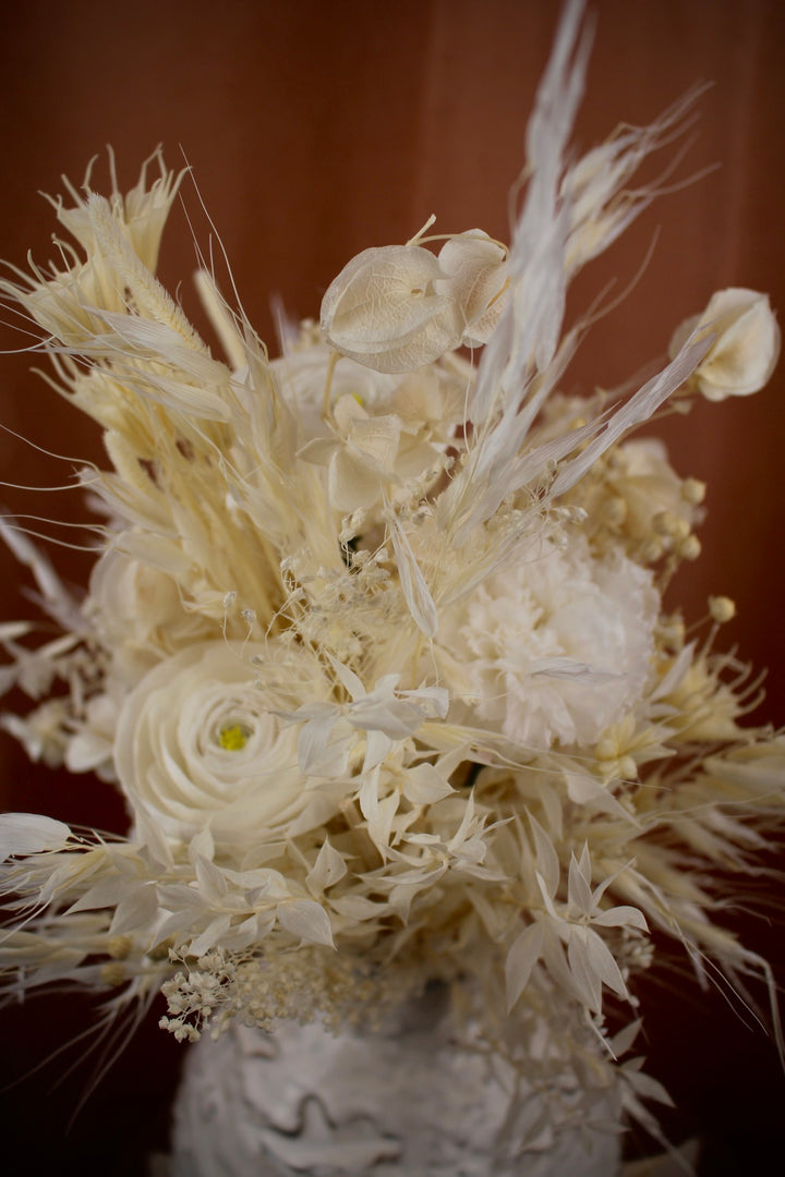 Trockenblumenstrauß in Weiß mit präparierten Ranunkeln und Nelken