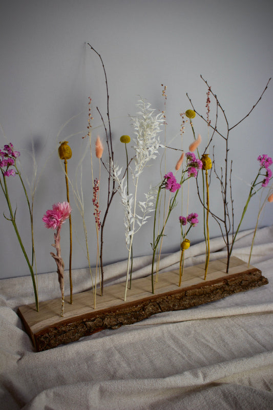 Blütenleiste ‚Frühlingserwachen‘ - DIY Set. Trockenblumen in Pink, Gelb und Weiß treffen auf naturbelassenes Eichenholz mit markanter Rinde.