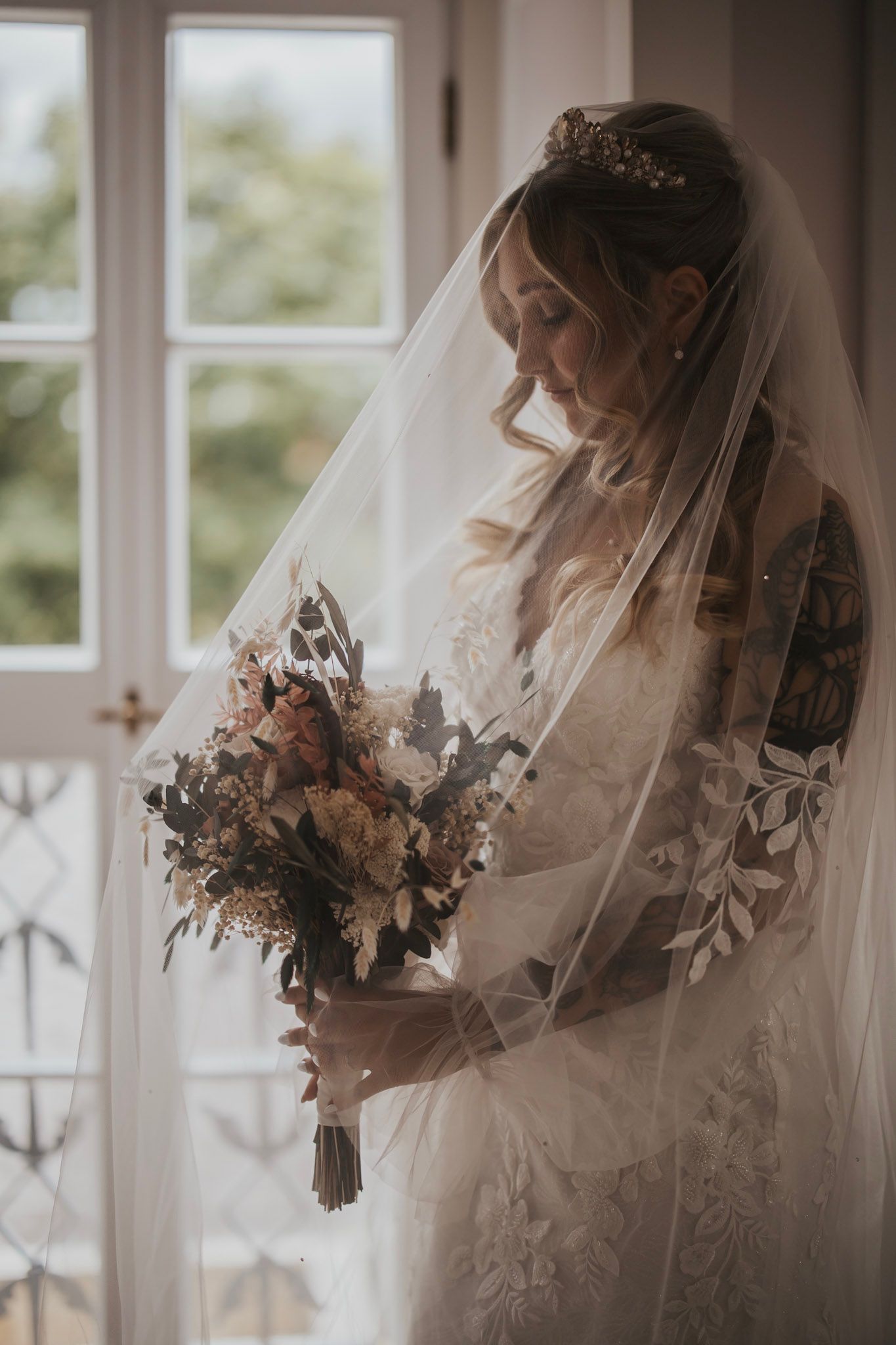 Brautstrauß aus Trockenblumen, präparierten Rosen, Eukalyptus und Olive bei einer Hochzeit